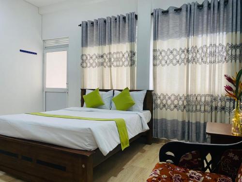 a bedroom with a bed with green pillows and curtains at Villa Mangofera in Galle