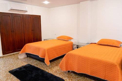 two beds sitting next to each other in a room at HOTEL GANADERO in La Dorada