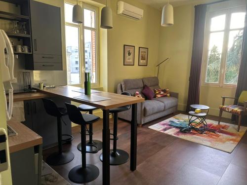 une cuisine et un salon avec une table et un canapé dans l'établissement T2 standing de La tour jayan, à Agen