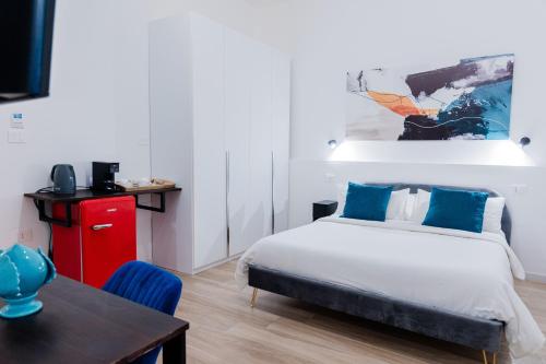 a bedroom with a bed and a desk and a table at Duomo Rooms - Manfredi Homes&Villas in Manfredonia