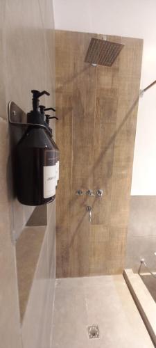 a soap dispenser on the wall of a shower at La Morada Apart in Cafayate