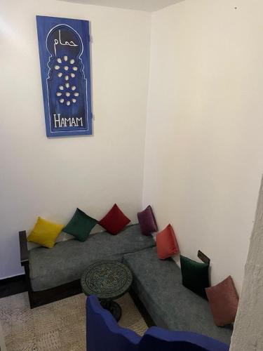 a living room with a couch with colorful pillows at Dar Nakhla in Chefchaouene