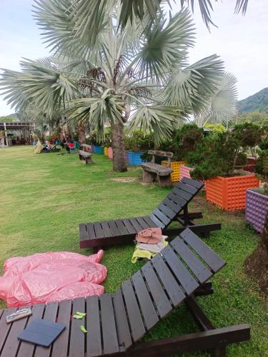 a picnic table with a sleeping bag on the grass at Glossy Marina Homestays in Lumut