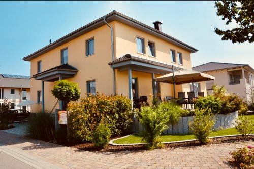 a large house with an umbrella in front of it at Gästehaus Dolce Vita in Rust