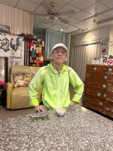 a man sitting at a counter with a cup of coffee at 集集藝術家背包客之家包層 in Jiji