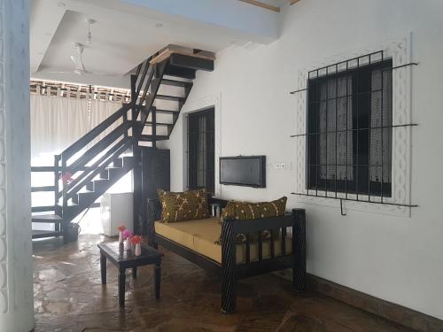 Una sala de estar con un sofá y una escalera. en The Foxy Nests of Karibuni - Villa 184 & 145, en Mambrui