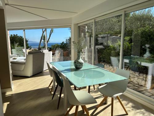 une salle à manger avec une table et des chaises en verre dans l'établissement Appartement , piscine aux portes de Monaco, à Cap d'Ail