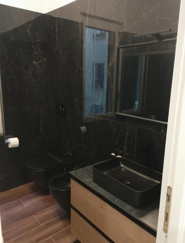 a black bathroom with two toilets and a sink at Stella Polare Sensorial Home in Lido di Ostia
