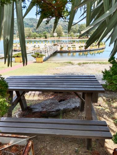 a wooden bench sitting next to a body of water at Glossy Marina Homestays in Lumut