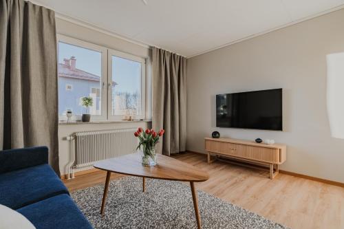 a living room with a blue couch and a tv at Förstklassig bekvämlighet! in Huskvarna