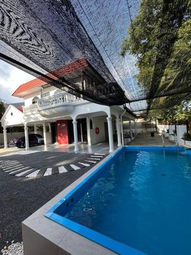 a large blue swimming pool under a building at Piano homestay in Alor Setar