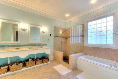 a bathroom with a tub and a shower and a sink at Watermark - 637 Demere Way in Demere Park