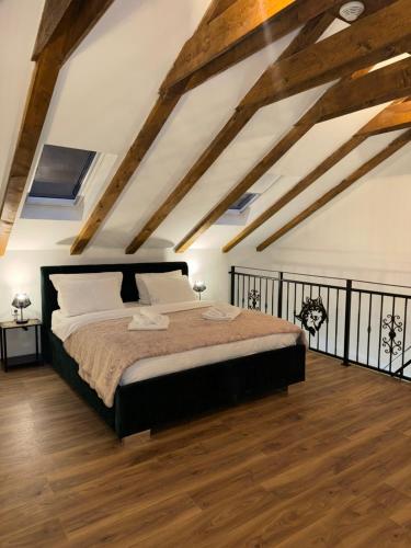 a bedroom with a large bed and wooden floors at Country House Lištani-renta quad in Livno