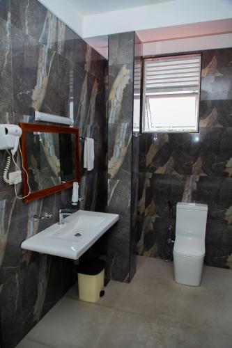 a bathroom with a sink and a mirror and a toilet at Heritage Grand - Badulla in Badulla