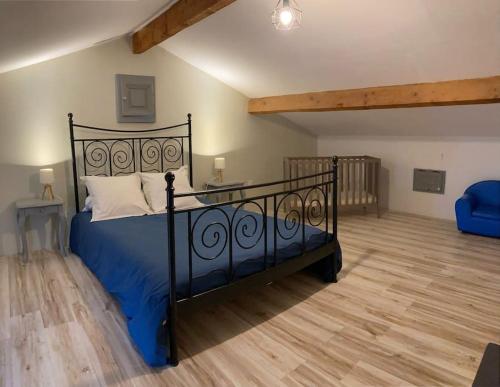 - une chambre avec un lit noir et une chaise bleue dans l'établissement Fenêtre sur les Cévennes, à Saint Julien Les Rosiers