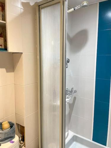 une douche avec une porte vitrée dans une salle de bain dans l'établissement Appartement spacieux avec Jardin à 500 des plages, au Grau-du-Roi