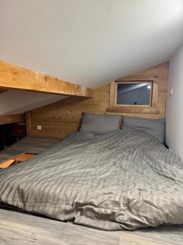 un grand lit dans une chambre avec une fenêtre dans l'établissement The Mountain View, aux Houches