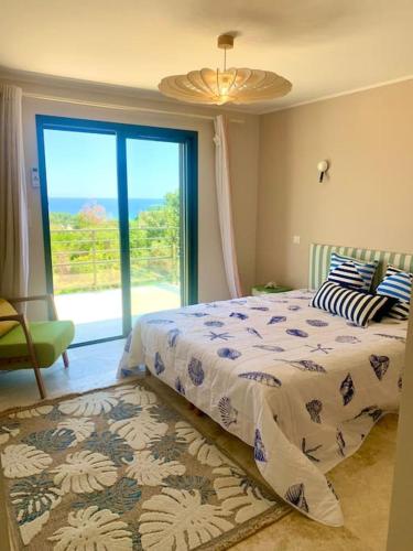 une chambre avec un lit et une grande fenêtre dans l'établissement Villa vue mer et piscine privée, à Sari-Solenzara