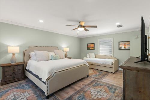 a bedroom with two beds and a flat screen tv at Soulful of Sunshine - 4314 Eleventh Street in Saint Simons Island