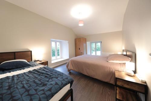 une chambre avec deux lits et deux fenêtres dans l'établissement La ferme d aumontzey, à Aumontzey