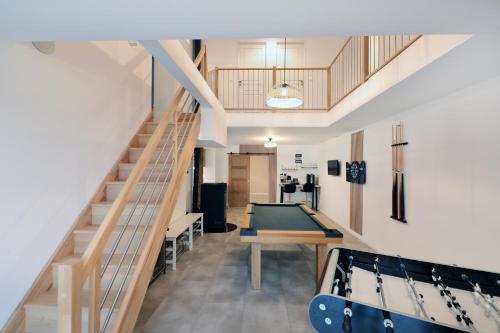 une pièce avec une table de billard et un escalier dans l'établissement La ferme d aumontzey, à Aumontzey