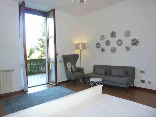 un salon avec un canapé, des chaises et une fenêtre dans l'établissement Casa Corsini, à Porto Valtravaglia