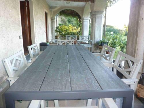une grande table en bois avec des chaises blanches autour dans l'établissement Casa Corsini, à Porto Valtravaglia