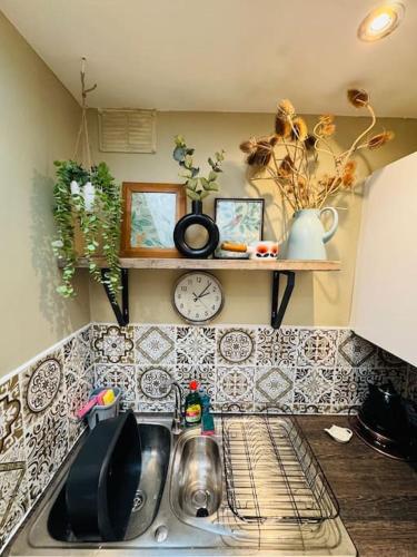 a kitchen counter with a sink and a clock at #11 Impressive and Spacious Studio Sleeps 4 - Perfect for Contractors and Families - Free Parking in Birmingham