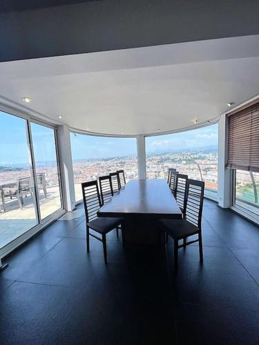 a table and chairs in a room with a view at MONT BORON - NICE - Splendide villa d'architecte vue panoramique in Nice
