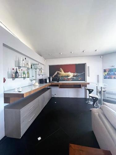 a kitchen with a couch and a tv on the wall at MONT BORON - NICE - Splendide villa d'architecte vue panoramique in Nice