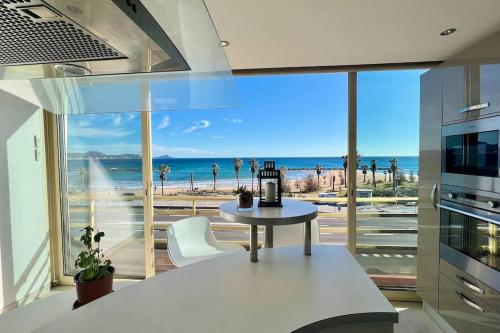 une cuisine avec une table et une vue sur l'océan dans l'établissement Studio spacieux, vue imprenable sur la mer, à Saint-Aygulf