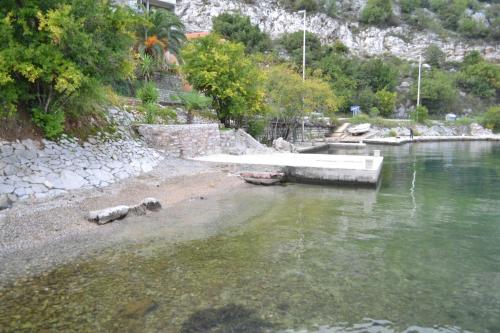 a body of water with a boat in it at Apartments Mijuskovic in Donji Morinj