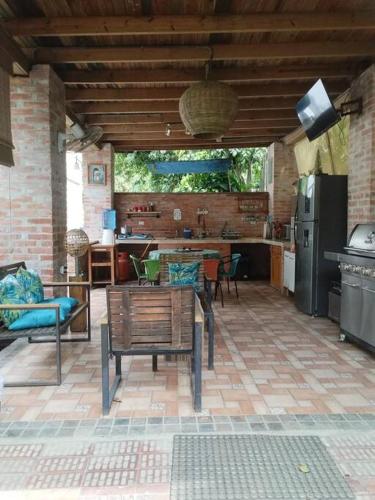 a patio with a table and chairs and a kitchen at Propiedad entera frente al mar con 3 habitaciones in Puerto Cortes