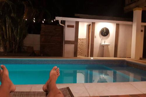 a person laying on the floor next to a swimming pool at Propiedad entera frente al mar con 3 habitaciones in Puerto Cortes