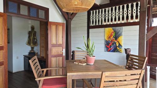 a dining room with a wooden table and chairs at Greenheart Boutique Hotel in Paramaribo
