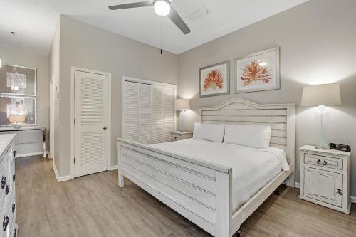 a white bedroom with a bed and a ceiling fan at Windemere 301 in Perdido Key