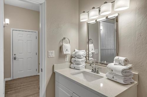 a bathroom with a sink and a mirror and towels at Windemere 301 in Perdido Key