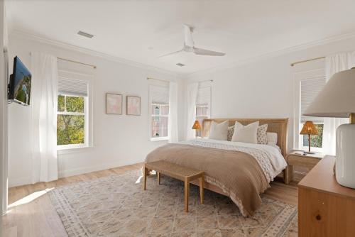 Un dormitorio blanco con una cama y dos ventanas. en The Ship's Belle - 912 Ocean Blvd, en Saint Simons
