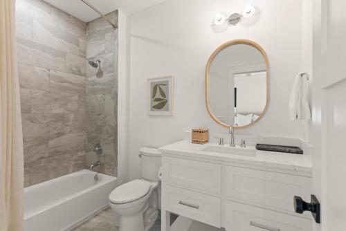 Un baño con lavabo, inodoro y espejo. en The Ship's Belle - 912 Ocean Blvd, en Saint Simons