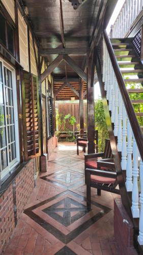 a porch of a house with stairs and benches at Greenheart Boutique Hotel in Paramaribo