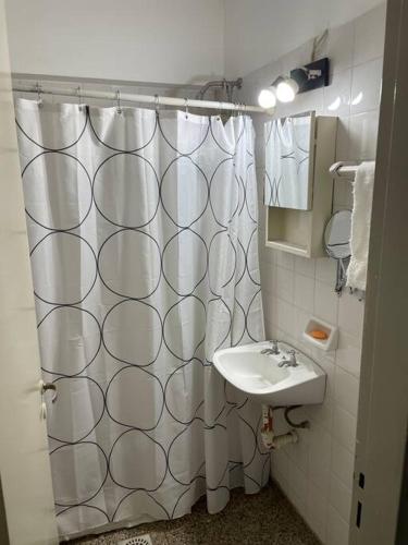 a bathroom with a shower curtain and a sink at Departamento amoblado, en centro in San Juan