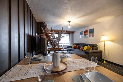 a dining room table with wine glasses and a couch at La Ruinette-one-bed Apartment In Verbier Centre in Verbier
