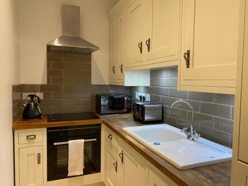 a kitchen with a sink and a stove top oven at Quay Apartment with parking in Aberdeen