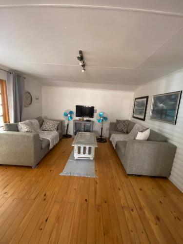 a living room with two couches and a table at Out of Africa on Vaal in Parys