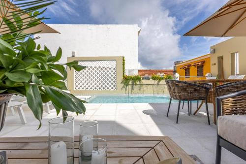 a patio with a table and chairs and a swimming pool at Hotel Casa del Gobernador in Cartagena de Indias