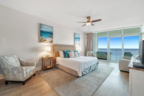 a bedroom with a bed and a balcony with the ocean at Turquoise C702 in Orange Beach