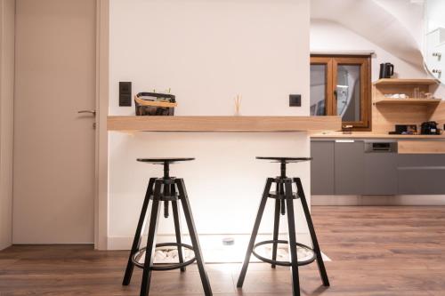 a kitchen with two bar stools in front of a counter at Thea Petra in Kalabaka