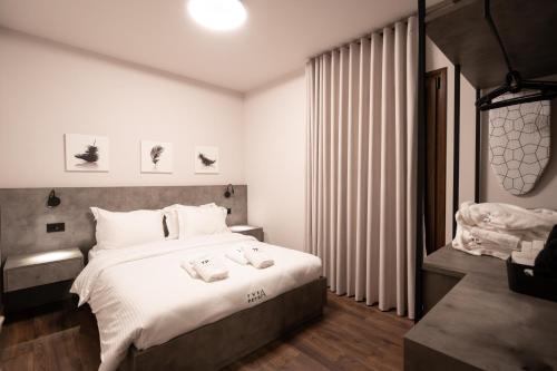 a bedroom with a large bed with white sheets at Thea Petra in Kalabaka