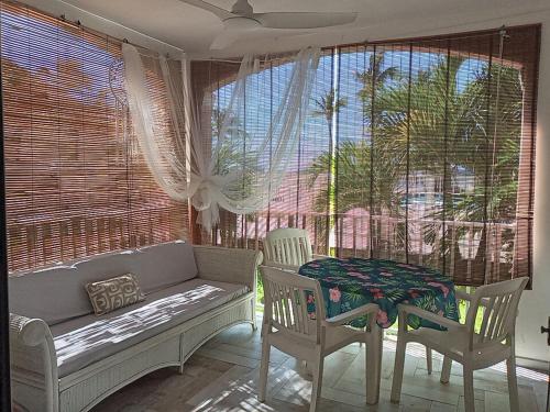 a living room with a couch and a table and chairs at Just in paradise in Baie Nettle