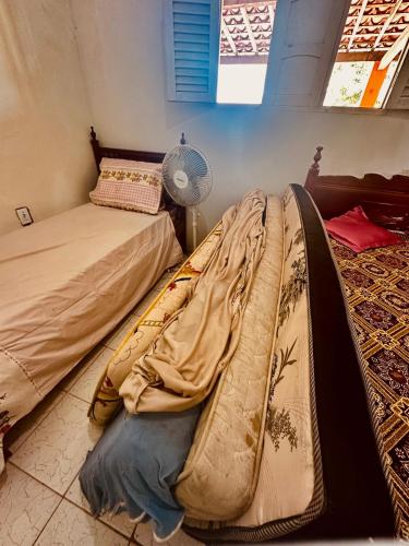 a bedroom with two beds and a fan at Casa de praia in Lucena